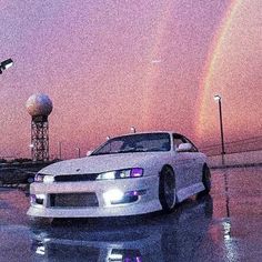 a white car parked in front of a rainbow