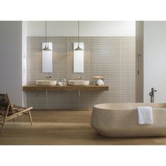 a bathroom with two sinks and a bathtub in the middle, along with a chair