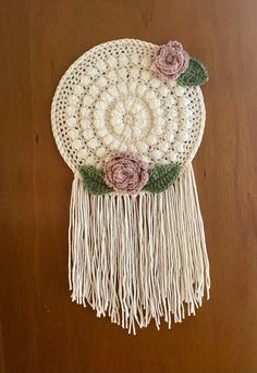 a crocheted doily with flowers on it sitting on top of a wooden table