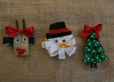 three paper christmas decorations sitting on top of a cloth covered floor next to each other