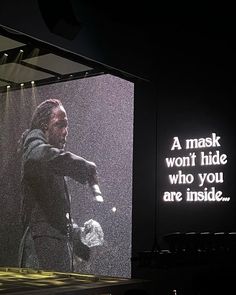 an image of a man in the rain on a large screen with words above it