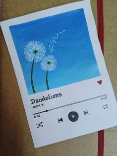 a drawing of dandelions on a piece of paper next to an mp3 player