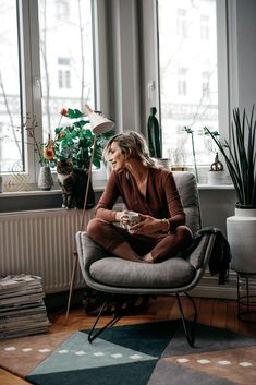 a woman sitting on a chair in front of a window