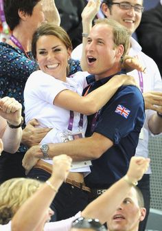 a man and woman hugging each other in the crowd