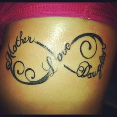 the back of a woman's stomach with a tattoo saying, mother and daughter