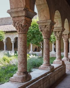 an outdoor area with stone pillars and plants