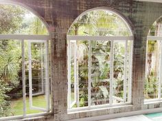 an open window with the view of a pool and palm trees in the back ground