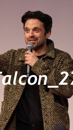 a man holding a microphone in his right hand with the words falcon - 22 on it