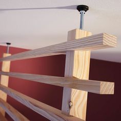 a close up of a wooden rail in a room with red walls and ceiling fan