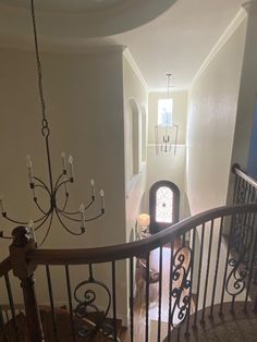 a staircase with chandelier and door leading up to the second floor in a house