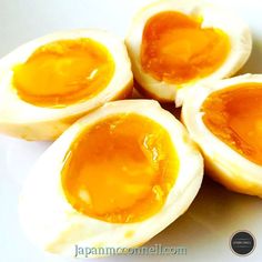 four hard boiled eggs sitting on top of a white plate with an egg yolk in the middle