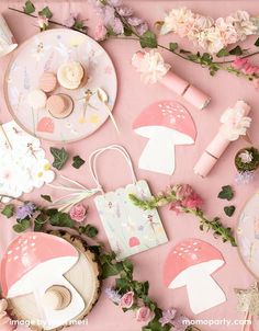 a table topped with lots of pink and white items on top of a pink surface