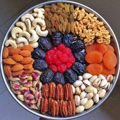 a metal bowl filled with nuts and dried fruits