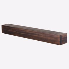 a wooden shelf sitting on top of a white wall