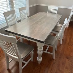 a dining room table with four chairs around it