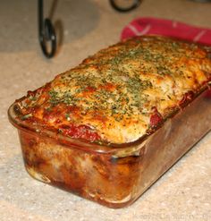 a casserole dish with meat, cheese and herbs in it on the counter