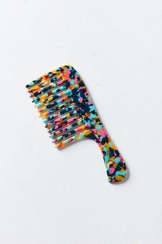 a toothbrush with colorful sprinkles on it sitting on a white surface