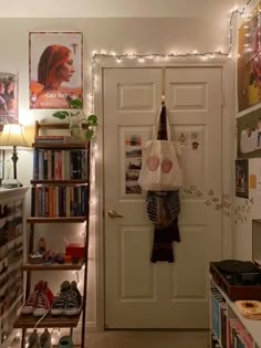 there is a white door and some shelves in the room with many books on it