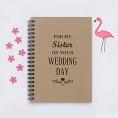 a notebook with the words for my sister on your wedding day next to pink flowers