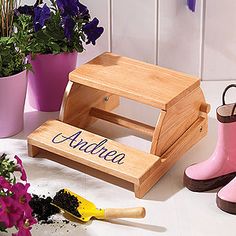 a wooden step stool with flowers in the background