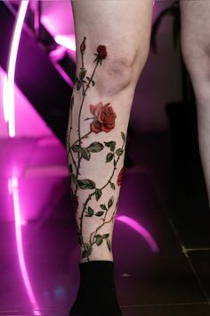 a rose tattoo on the leg of a woman