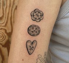 a woman's arm with tattoos on it and two heart shaped cookies in the middle