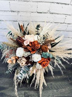 an arrangement of flowers and feathers on a wooden surface