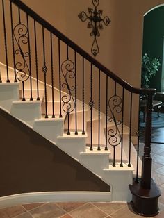 a staircase with wrought iron handrails and tile flooring in an upscale home