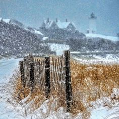 a wooden fence sitting in the middle of a snow covered field