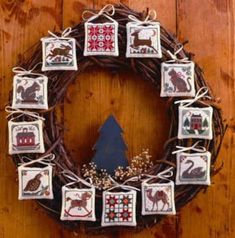 a cross stitch wreath is decorated with animals and other things to decorate on the front door