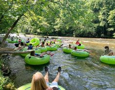 people are floating on inflatable tubes down a river