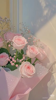 a bouquet of pink roses sitting on top of a table