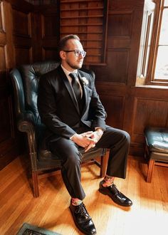 a man in a suit and tie sitting on a chair