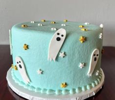 a blue cake decorated with ghost and stars