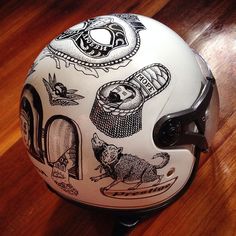 a white helmet with drawings on it sitting on top of a wooden floor