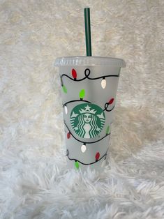 a starbucks cup decorated with christmas lights and a straw