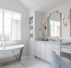 a white bathroom with a tub and two sinks