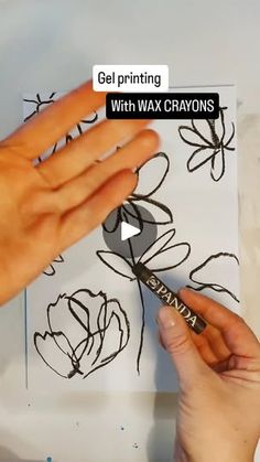 someone is drawing flowers with wax crayons on the paper and then using it