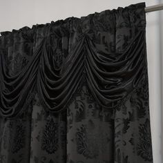 the black curtains are hanging on the wall