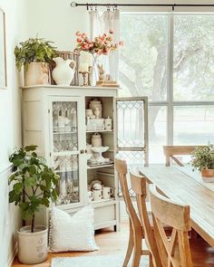 a dining room table and chairs in front of a window