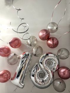 the number six is surrounded by balloons and streamers in pink, silver and white