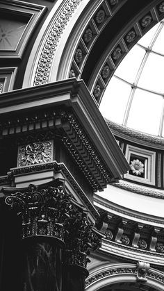 black and white photograph of the inside of a building with an arched glass window above it