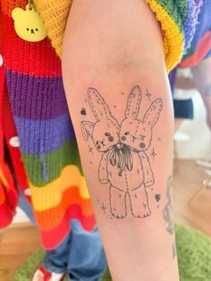 a person with a tattoo on their arm that has an image of two bunnies