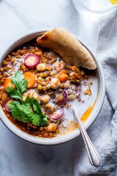 a bowl filled with beans and vegetables next to a spoon