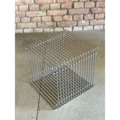 a metal basket sitting on top of a cement floor