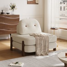 a living room with a white couch and wooden furniture