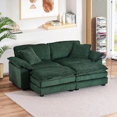 a green couch sitting on top of a hard wood floor next to a white rug