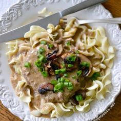 a white plate topped with pasta covered in mushroom sauce