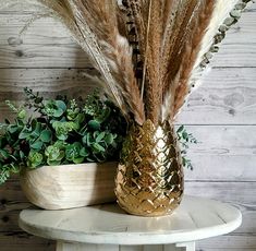 two vases filled with plants sitting on top of a table