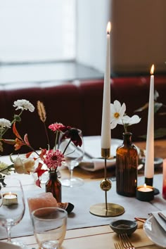 the table is set with flowers and candles